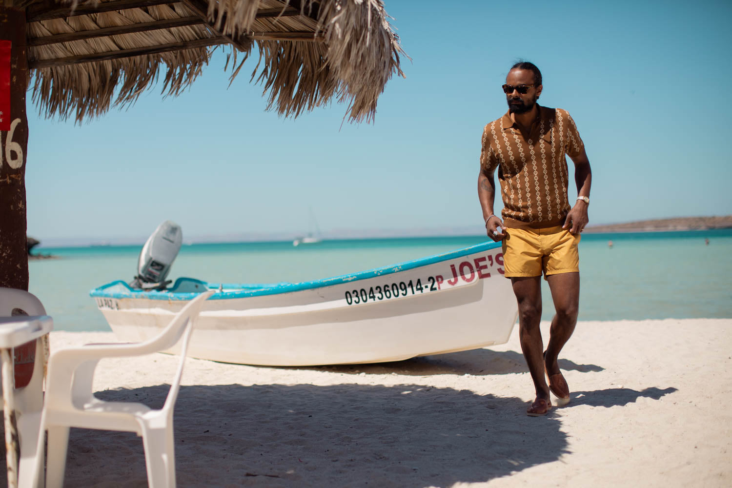 man standing besides the boat has wearing the dandy del clothes