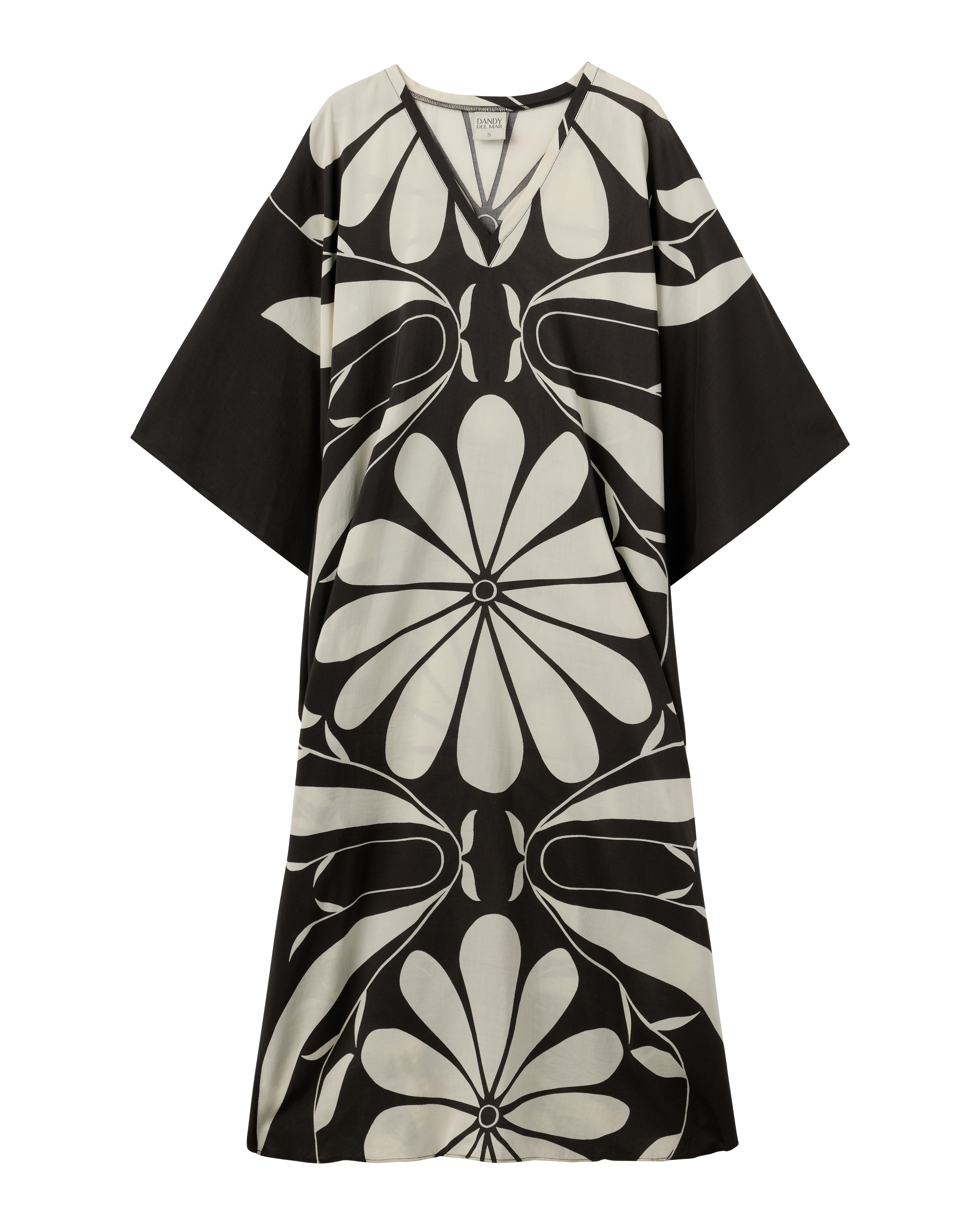 The Tropea Kaftan - Albatross by Dandy Del Mar is a loose-fitting black dress with wide sleeves, a bold white floral pattern, and a V-shaped neckline.