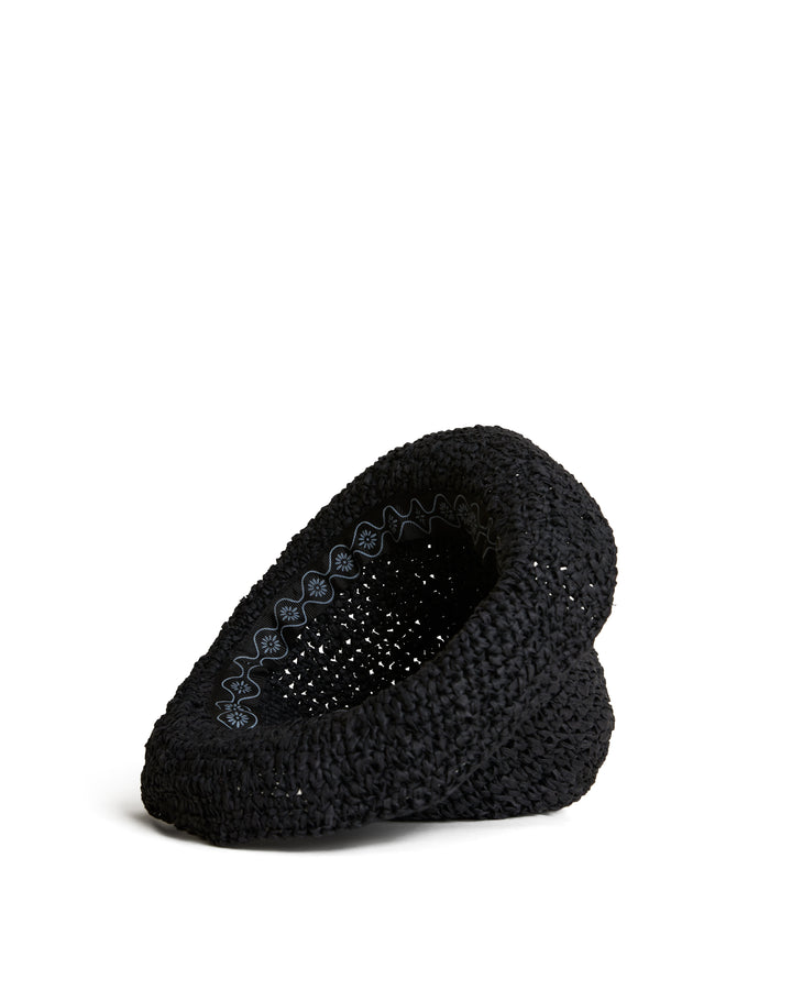 A single black raffia-effect crochet slipper with a scalloped pattern lining on a white background, The Amabile Raffia Hat - Onyx by Dandy Del Mar.