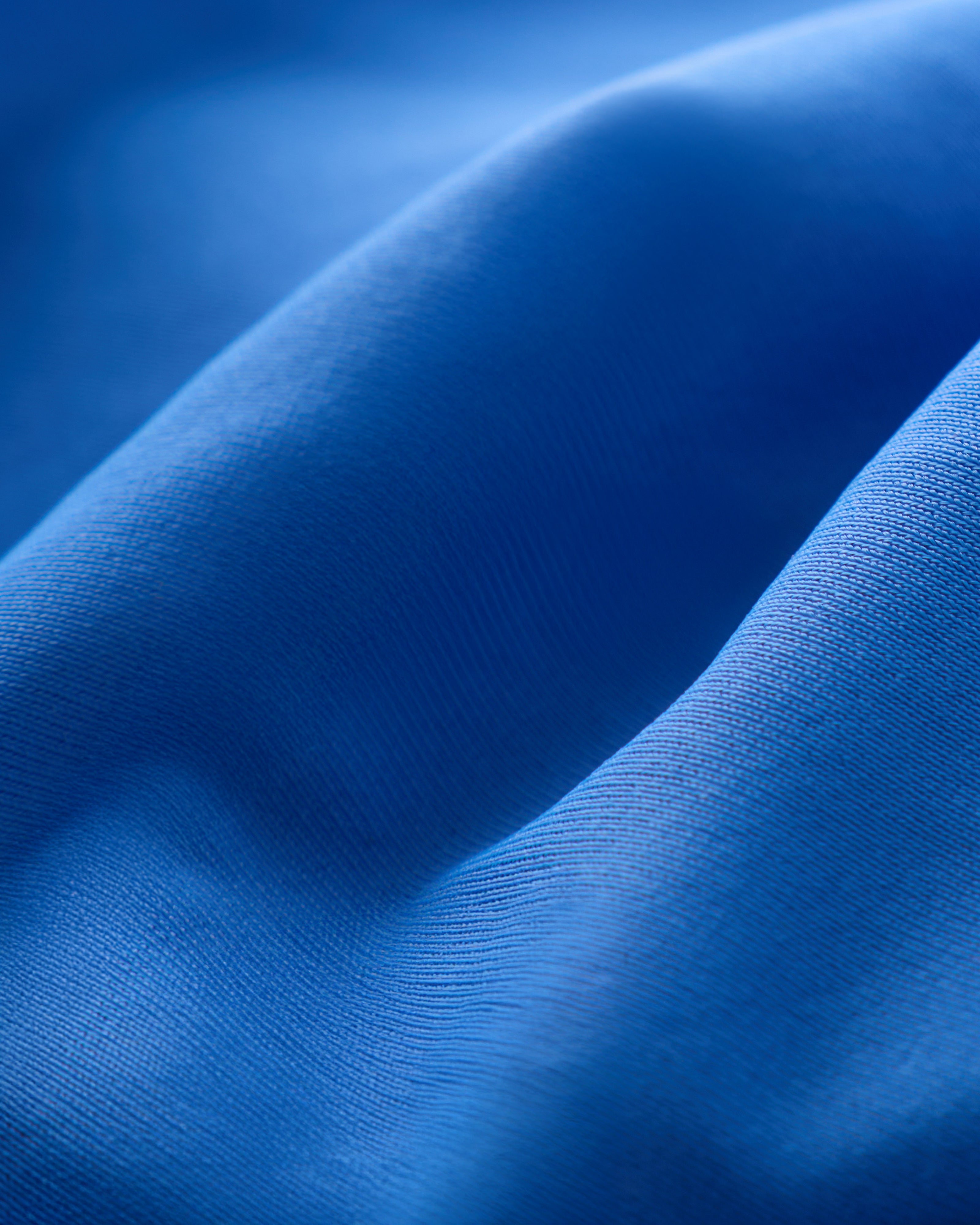 Close-up of The Avila Top - Solana by Dandy Del Mar, featuring blue recycled nylon fabric with visible texture and soft, undulating folds.