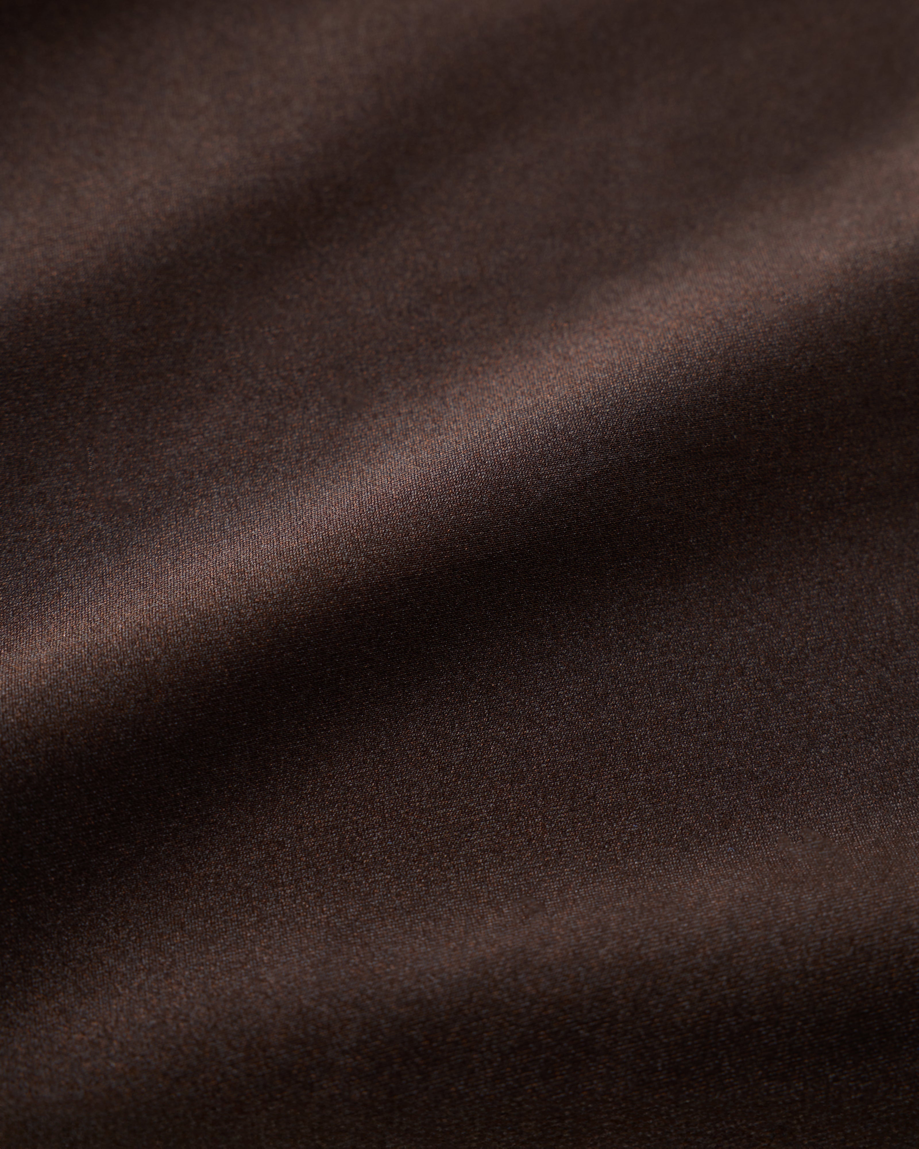 Close-up of The Avila Top - Tierra by Dandy Del Mar, featuring smooth, dark brown recycled nylon fabric with soft folds and a subtle sheen.