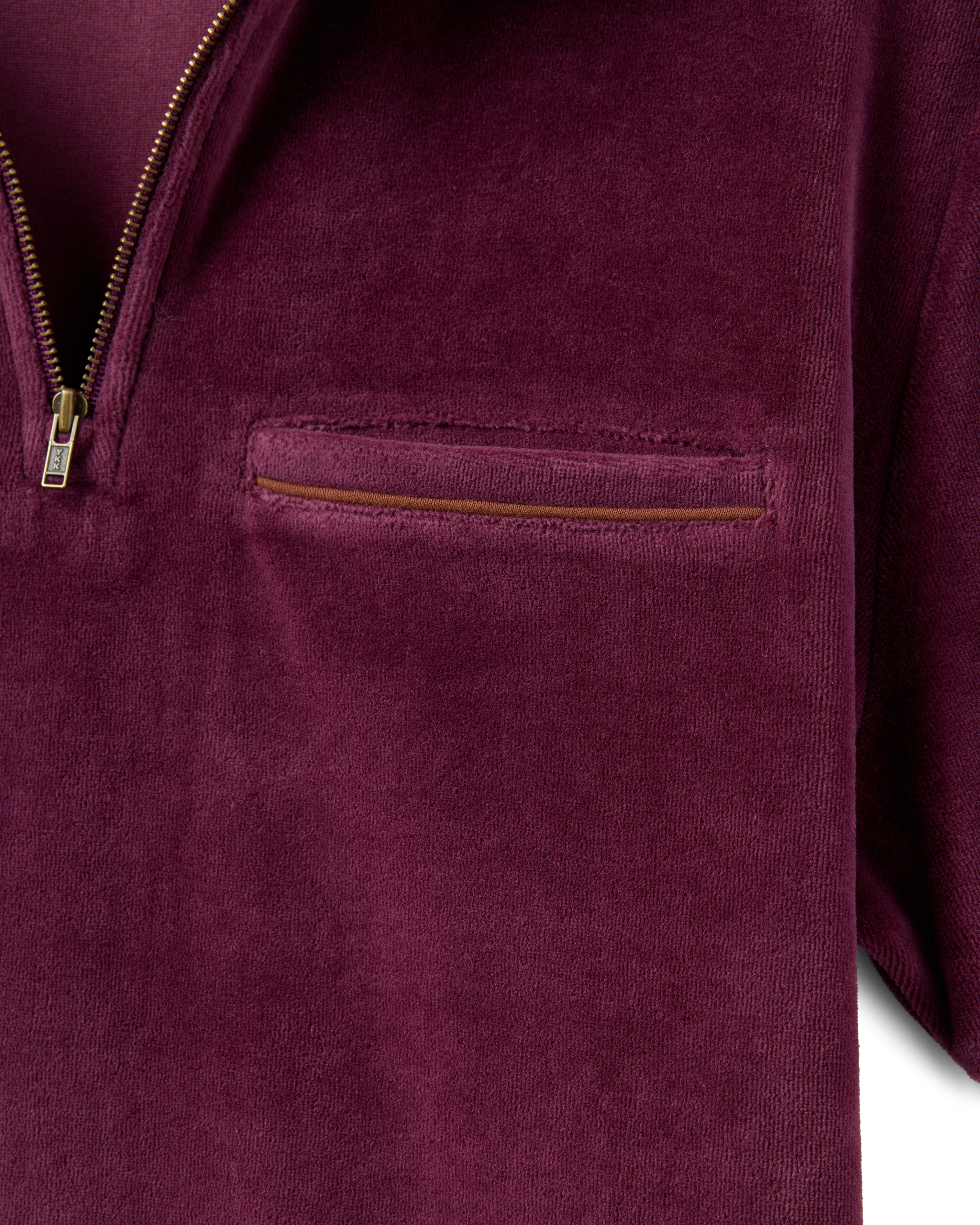 Close-up of The Rio Velour Shirt - Bordeaux by Dandy Del Mar, a maroon polo shirt with velour fabric, antique brass zipper, and a single chest pocket featuring a matching zipper detail.