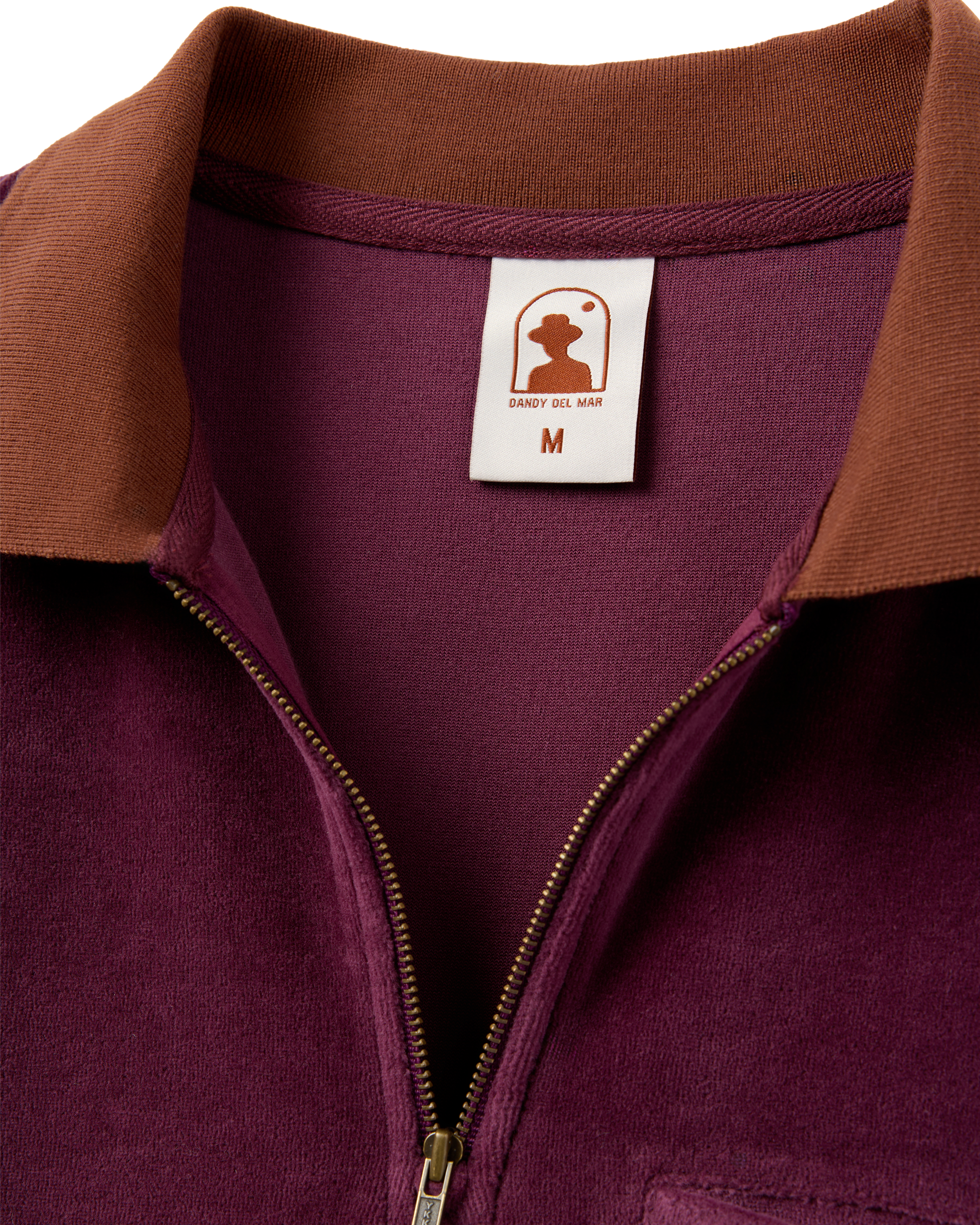 Close-up of The Rio Velour Shirt - Bordeaux by Dandy Del Mar, a maroon and brown luxury velour polo with a 3/4 zip design and visible size medium label.