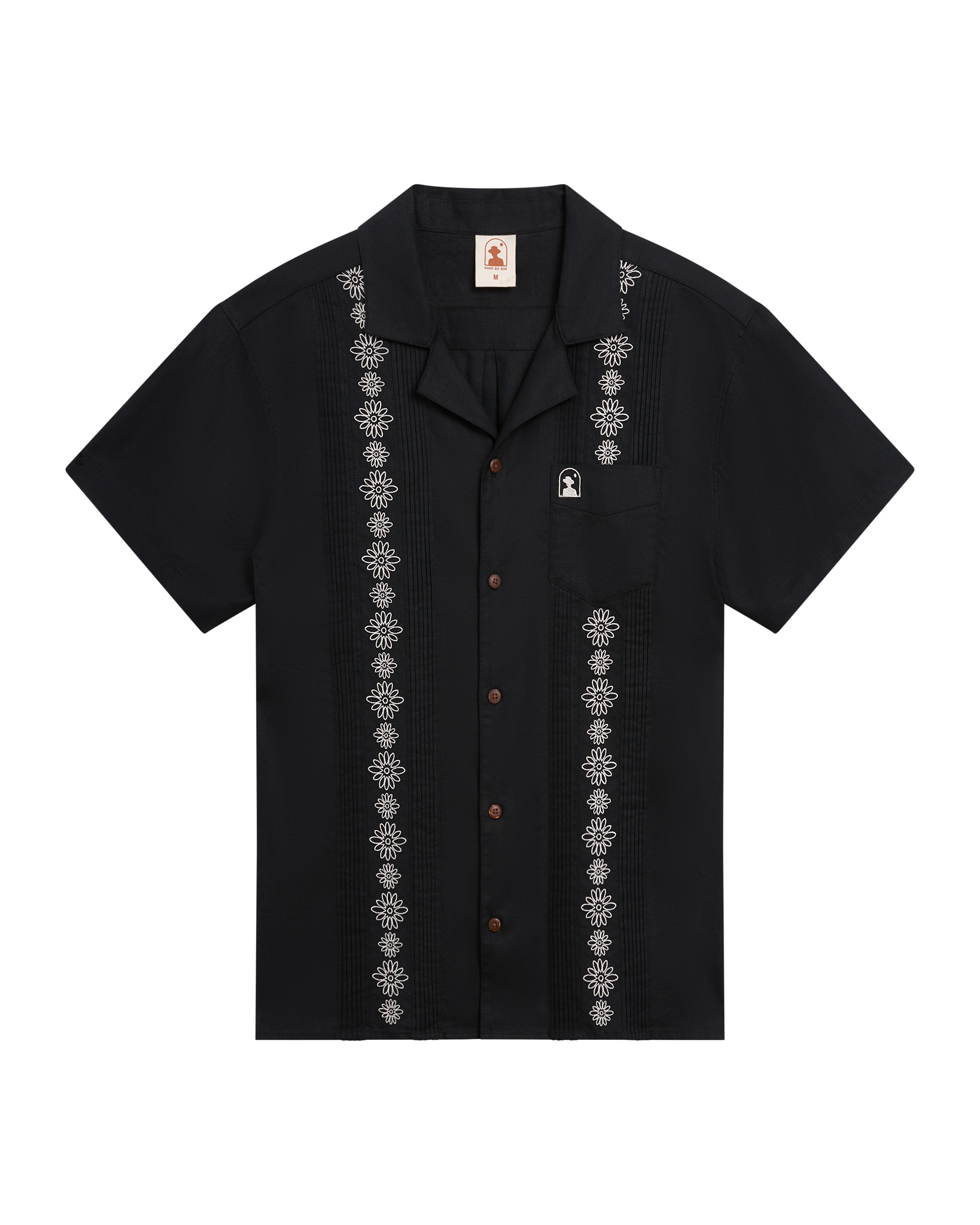 The Brisa Linen Shirt - Onyx by Dandy Del Mar: a short-sleeve black linen shirt with vertical white gardenia embroidery, chest pocket, and coconut shell buttons, shown laid flat on a white background.