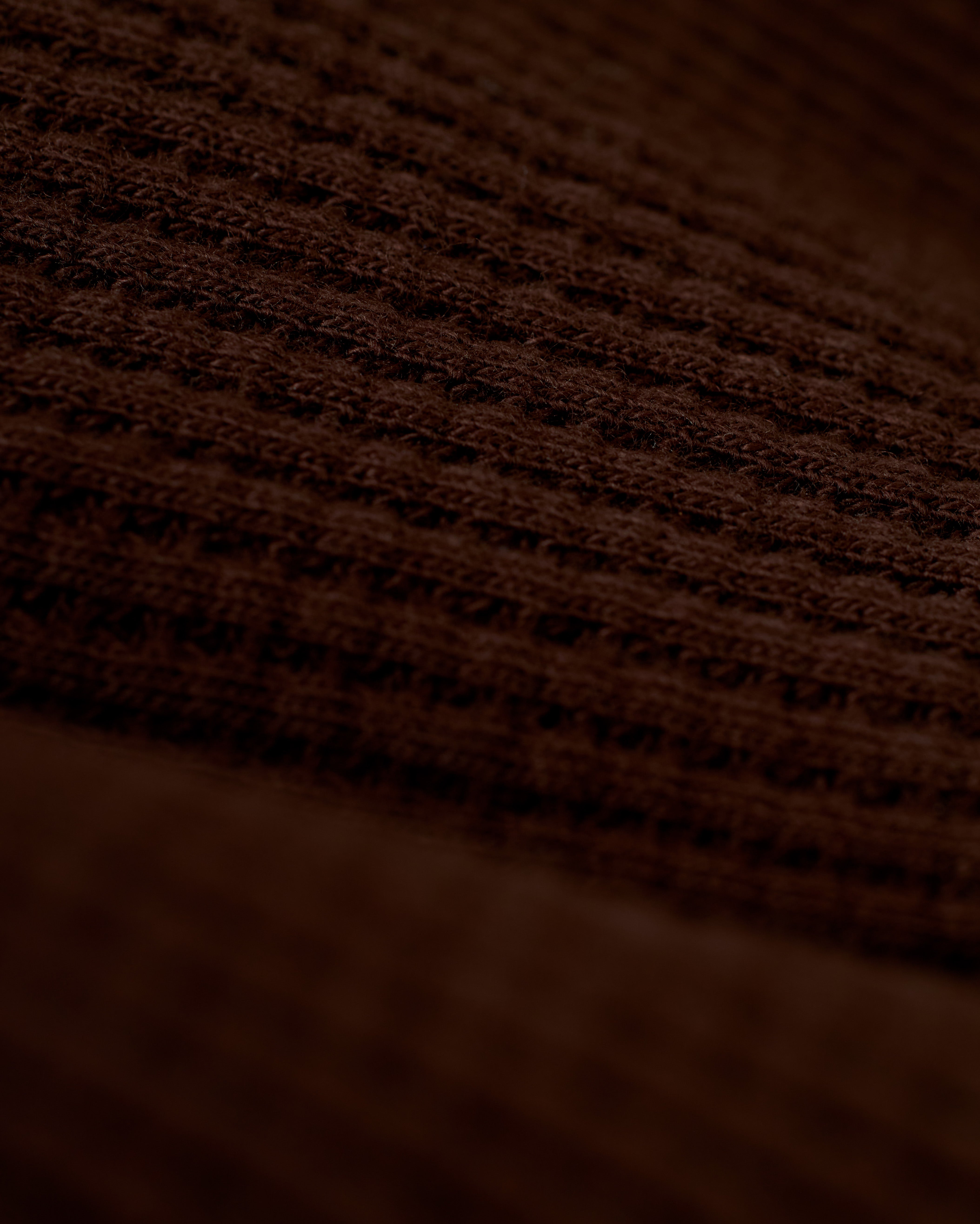 A close-up view of the brown 100% cotton fabric with a waffle weave pattern, reminiscent of the exquisite texture found in Dandy Del Mar's The Cannes Waffle Knit Robe - Carajillo.