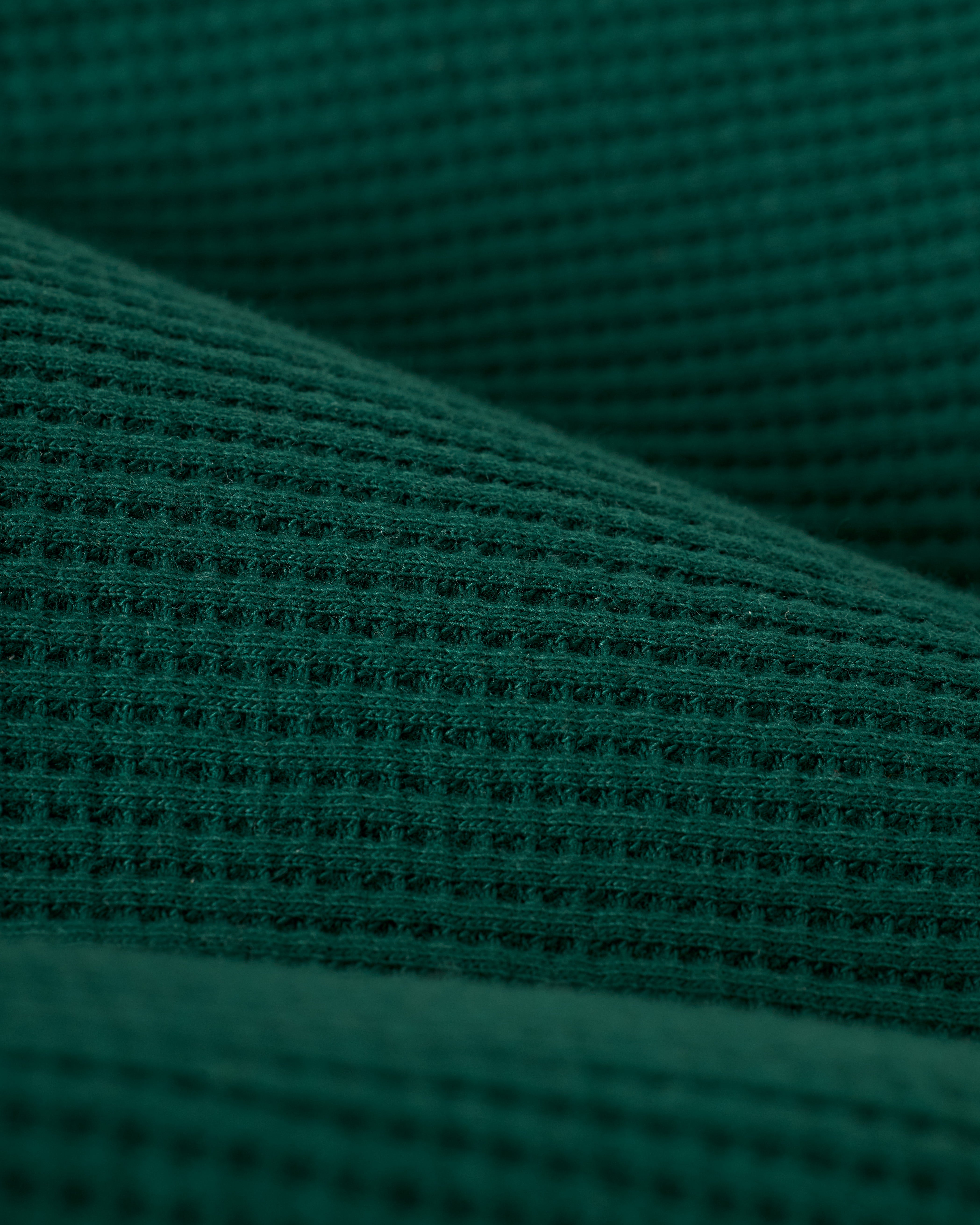 Close-up of The Cannes Waffle Knit Shirt - Albero by Dandy Del Mar, featuring a textured green fabric with a grid-like pattern.