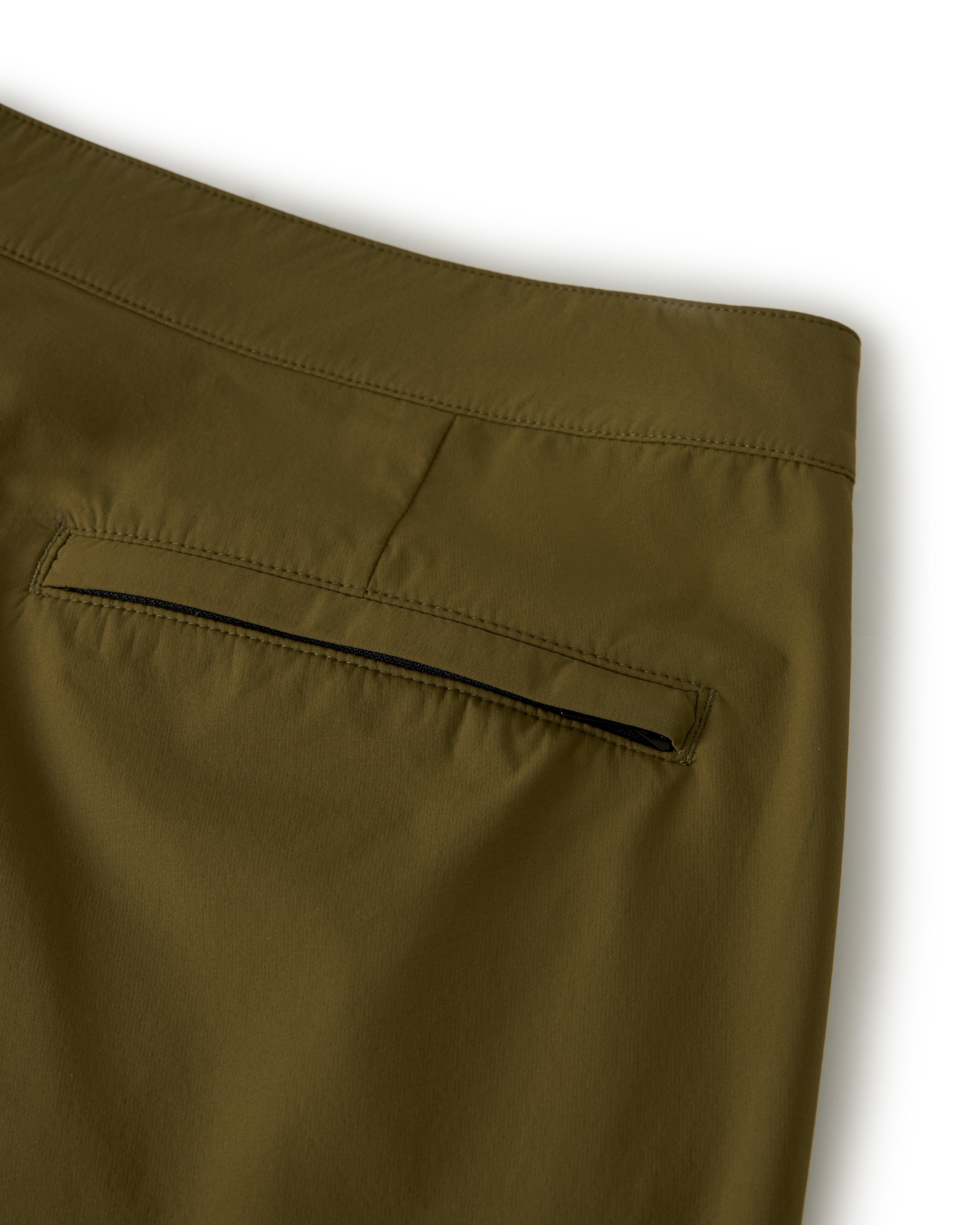 Close-up of The Cavoli Swim Short - Berdea by Dandy Del Mar, showcasing an olive green 4-way stretch fabric with a single welt pocket and black lining from the back.