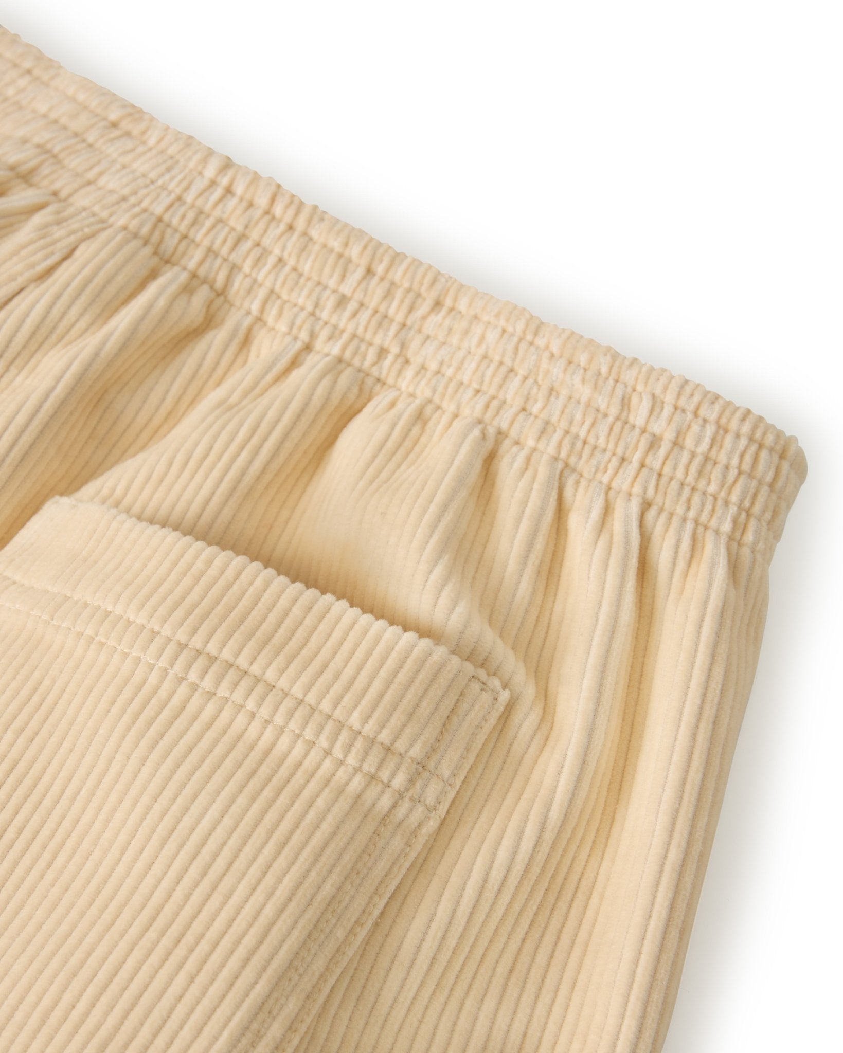 Close-up of The Corsica Corduroy Shorts - Scallop by Dandy Del Mar in beige, featuring a 5 inch inseam, elastic waistband, and visible side pocket.