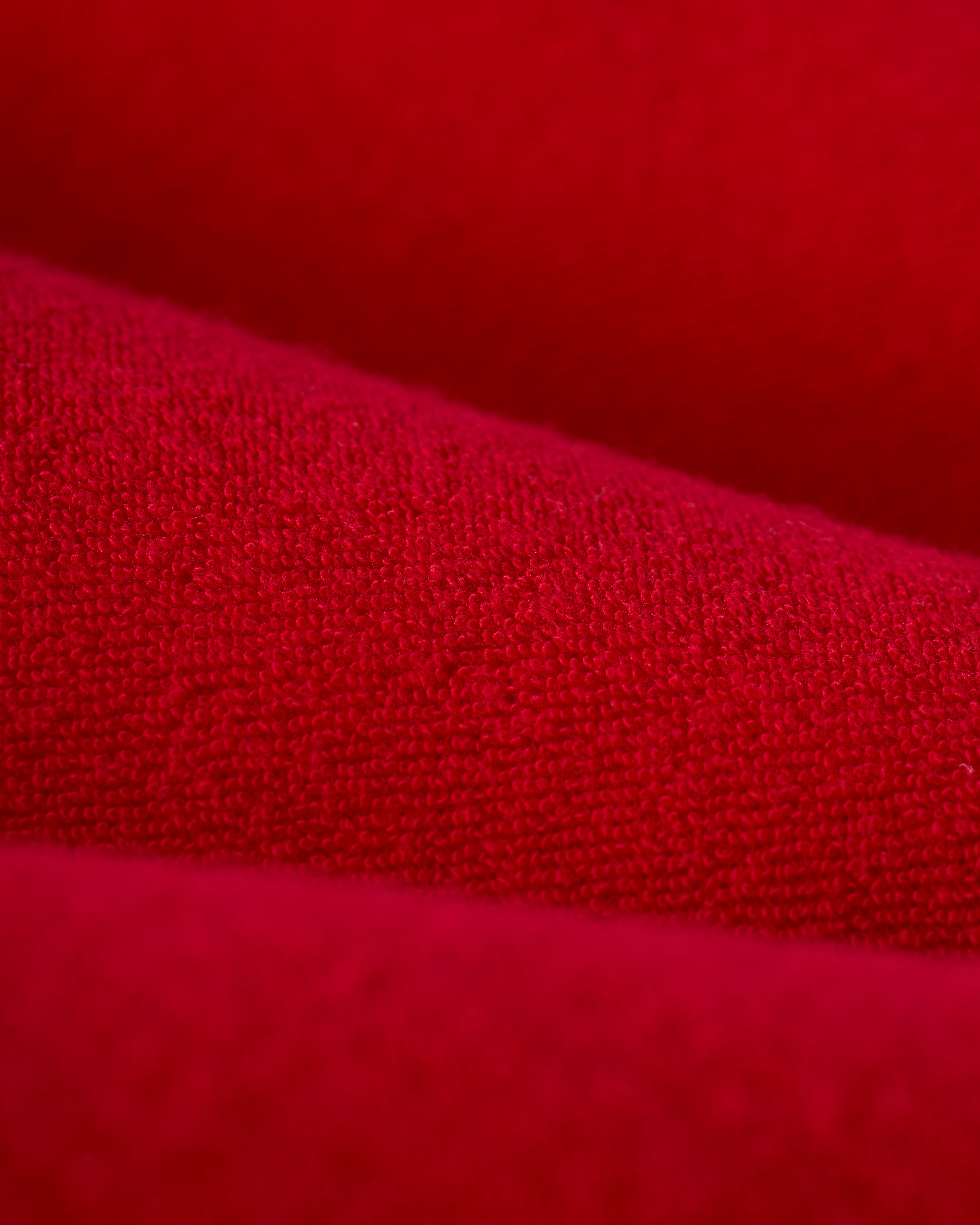 Close-up of The Cyprus Dress - Pico by Dandy Del Mar, showcasing its red terry cloth fabric with visible fibers and soft folds.