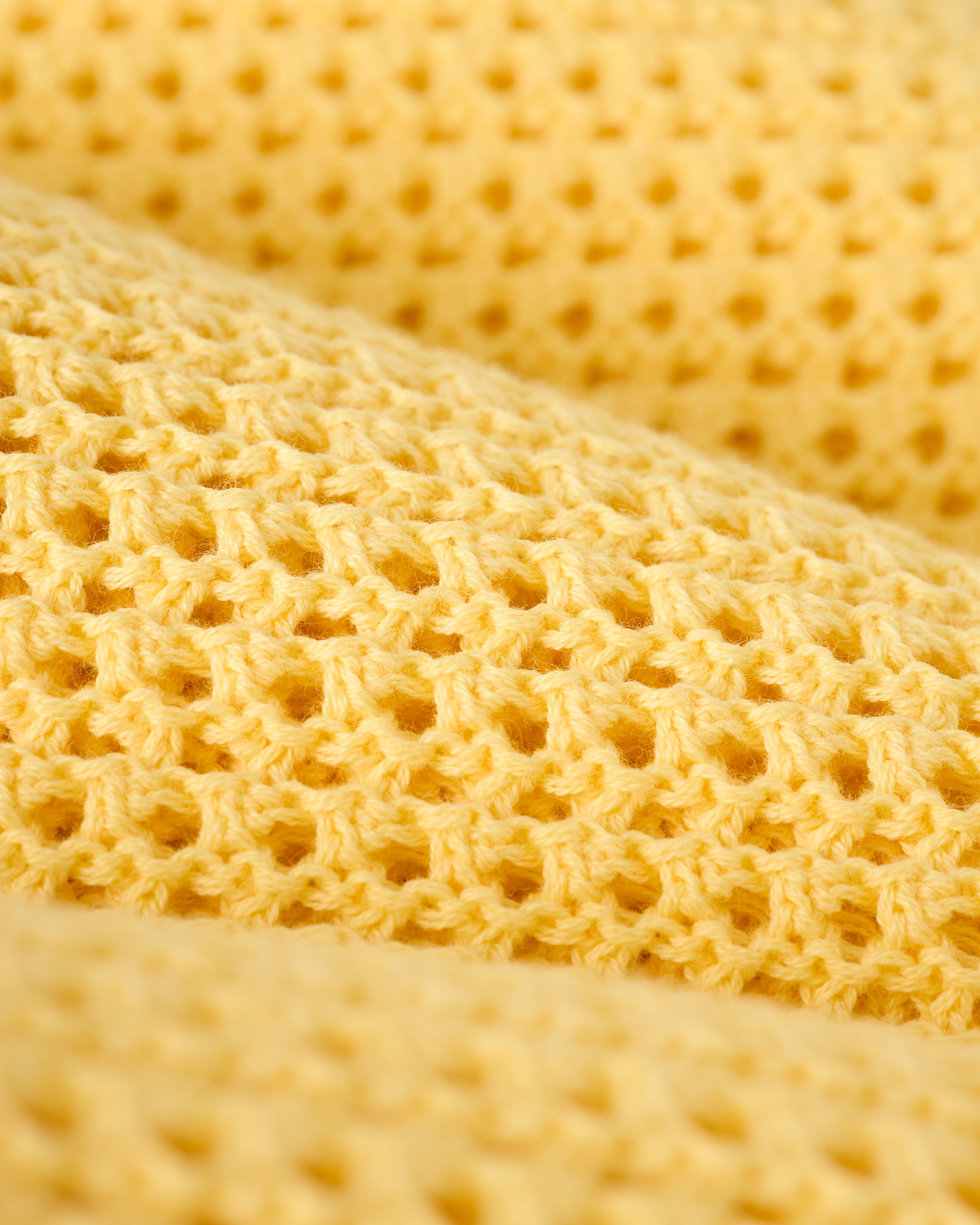 Close-up of Dandy Del Mar's Dominica Crochet Tank in Plantain, featuring a yellow honeycomb-patterned textured fabric, ideal for a lightweight crochet top.