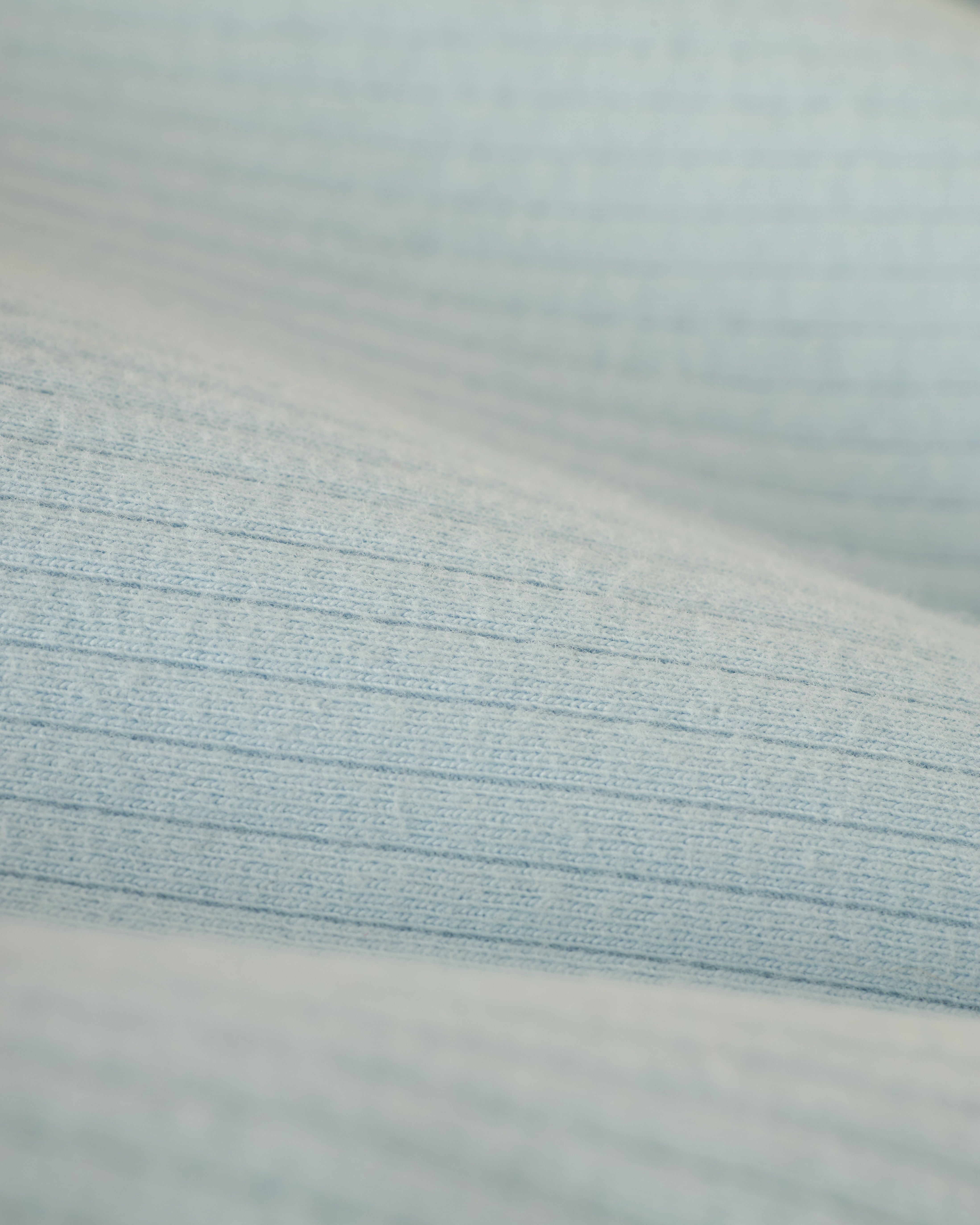 Close-up of The Milan Rib Tank - Comet by Dandy Del Mar, showcasing its light blue, textured fabric with subtle horizontal lines—a true reflection of luxury in simplicity.