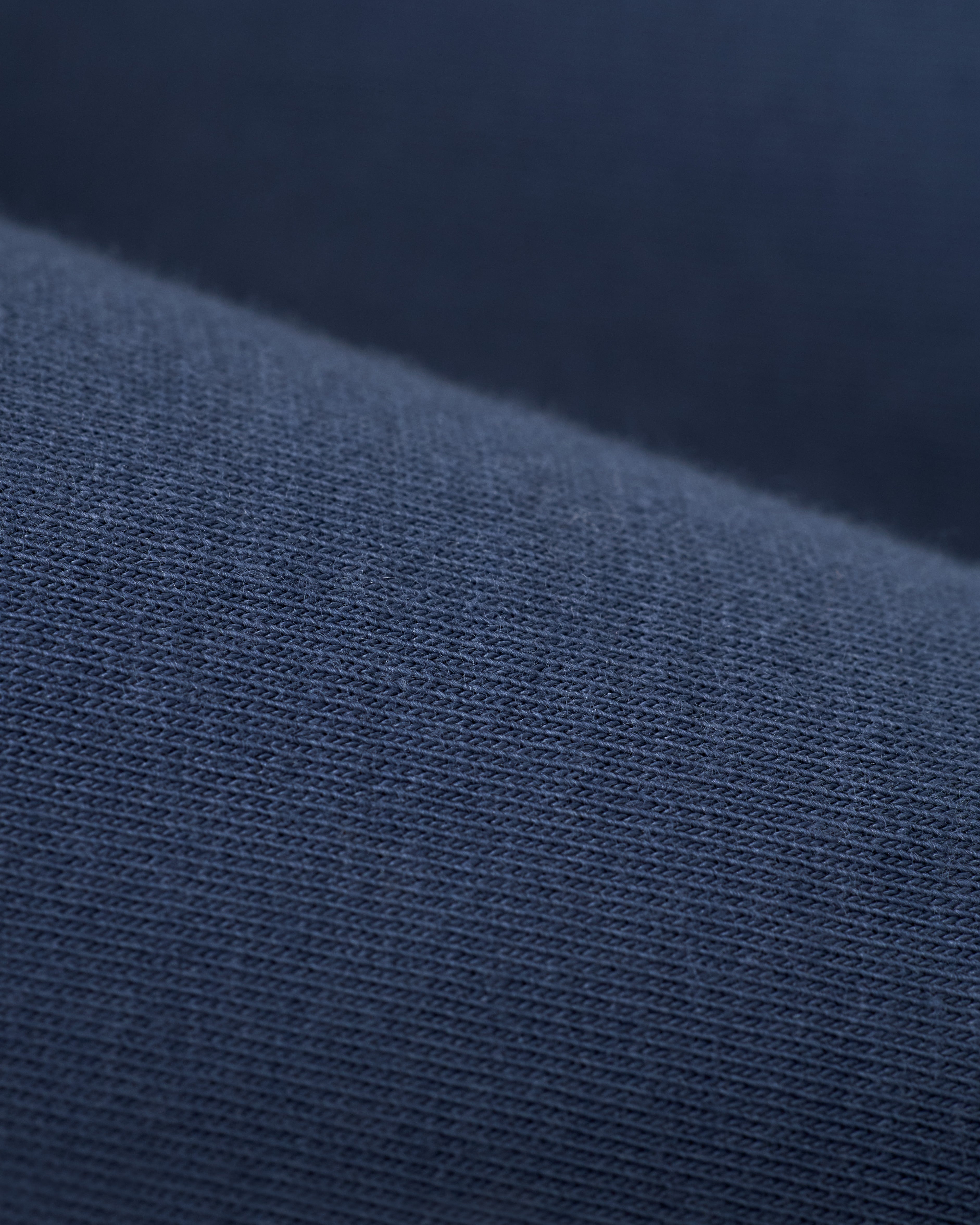 Close-up of dark blue fabric, displaying a fine knit texture with evenly spaced threads, ideal for crafting The Nassau Tee - Moontide by Dandy Del Mar.