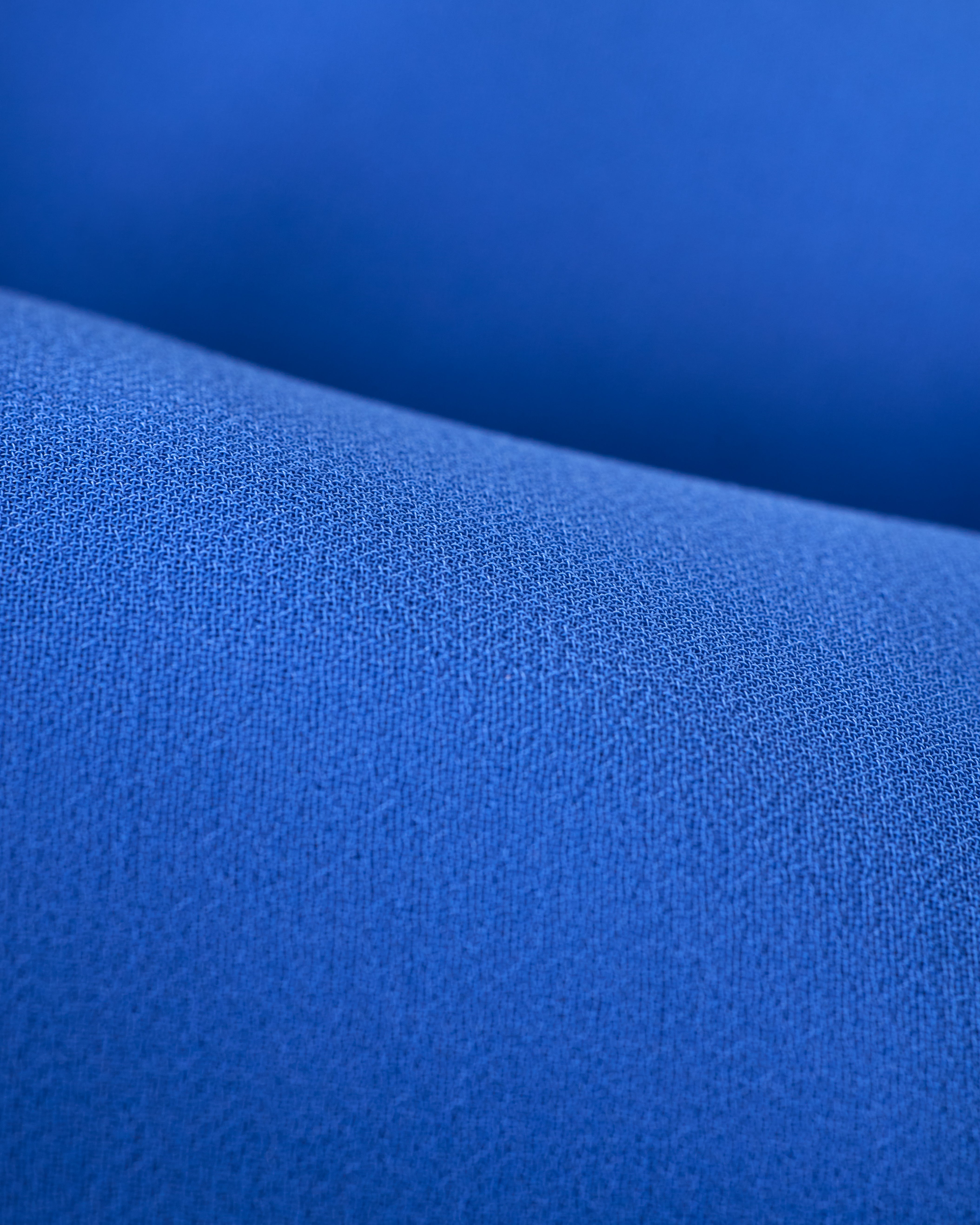 Close-up of The Zante Top - Solana from Dandy Del Mar, featuring a textured blue fabric with a smooth surface and gentle folds, akin to the elegant flow of an open-back chiffon cape.