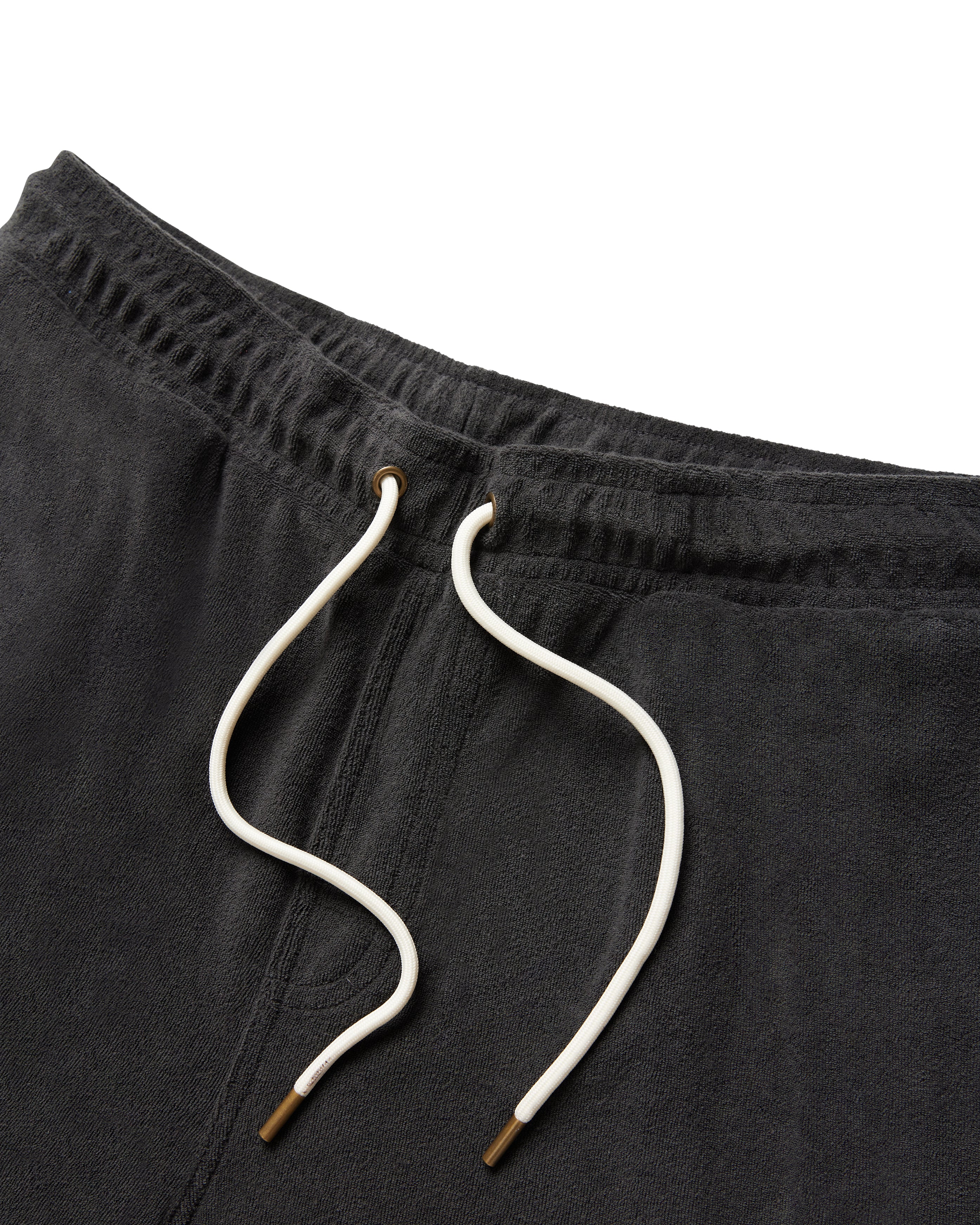 Close-up of The Gaucho Shorts - Onyx by Dandy Del Mar, featuring a dark gray terry cloth texture, white drawstrings with metallic tips, and detailed waistband design.