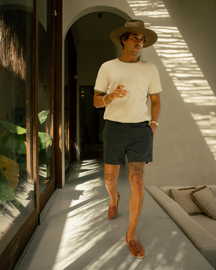 a man wearing a Dandy Del Mar Cannes Waffle Knit Tee - Vintage Ivory and shorts.
