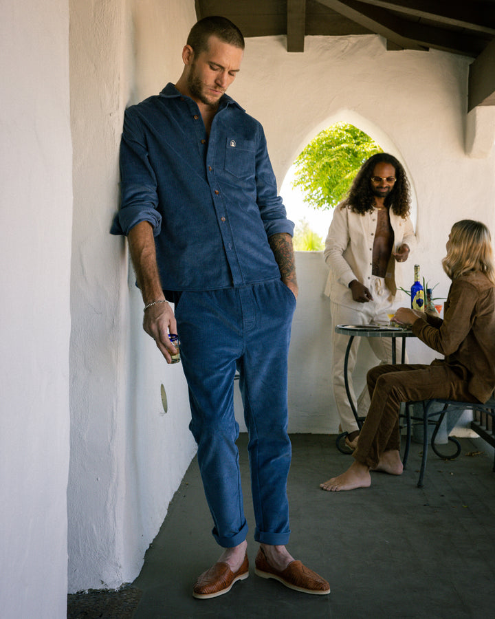 A man is standing in The Corsica Pant - Moontide by Dandy Del Mar.