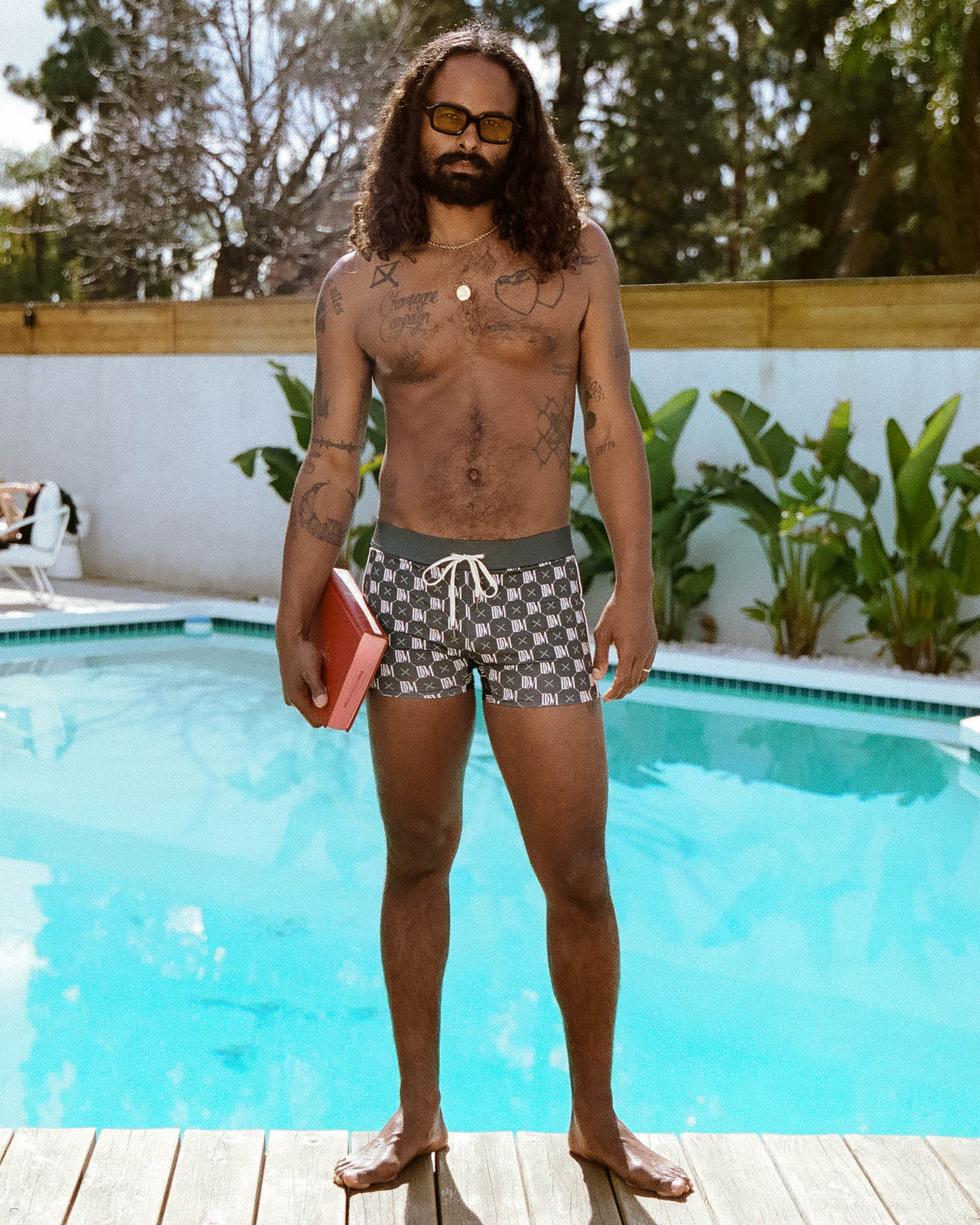 Man standing near swimming pool wearing dandy del swim wear