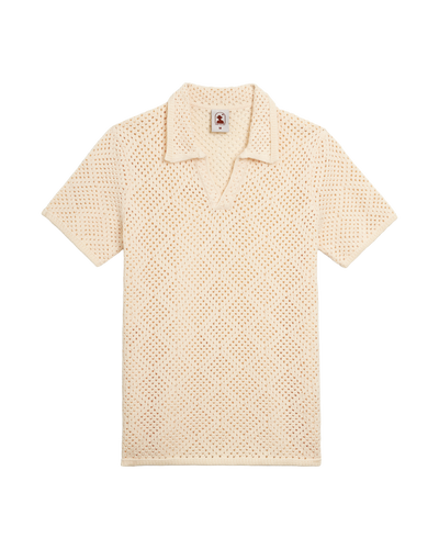 The Antibes Crochet Polo Shirt by Dandy Del Mar in Vintage Ivory features short sleeves, a collar, V-neck, and subtle diamond pattern knit, shown against a plain white background.