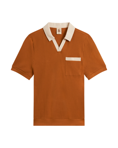 The Dandy Del Mar Cannes Waffle Knit Polo Shirt in Burnt Sienna features short sleeves, a cream contrast collar, chest pocket with trim, and waffle knit fabric—all shown against a plain white background.