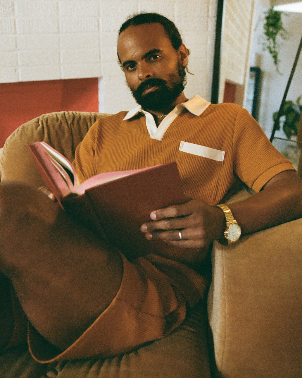 man sitting , having book in hand and wearing dandy del cloths