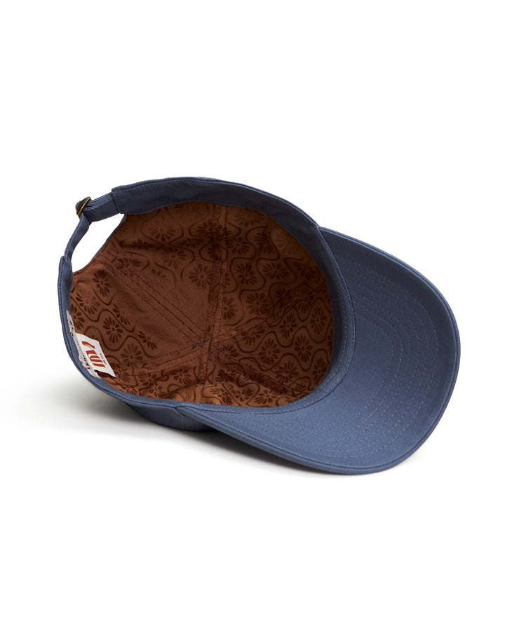 A blue Dandy Icon Hat - Moontide with a brown leather patch by Dandy Del Mar.