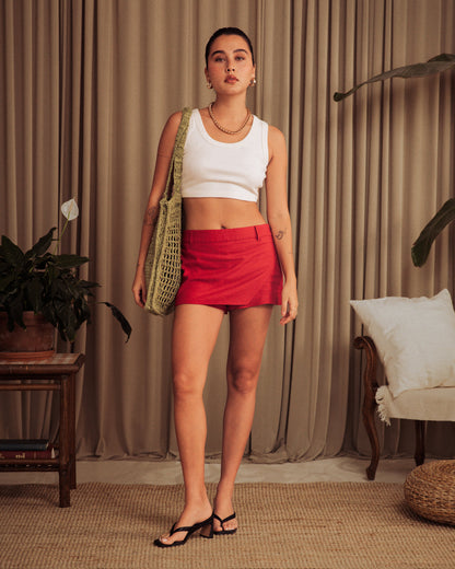 A woman wearing The Seine Rib Tank - Shell by Dandy Del Mar and a red skirt.