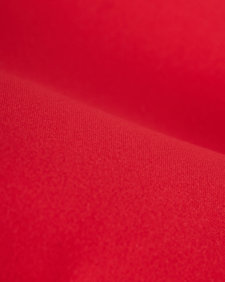 Close-up view of a textured red fabric with a soft appearance and slight shading variations, reminiscent of the luxurious recycled nylon used in Dandy Del Mar's The Avila Top - Pico's supportive underwire design.