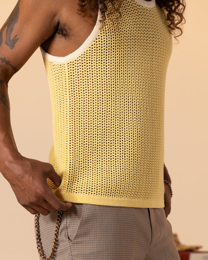 A person wearing The Dominica Crochet Tank in Plantain by Dandy Del Mar and plaid pants with chain details.