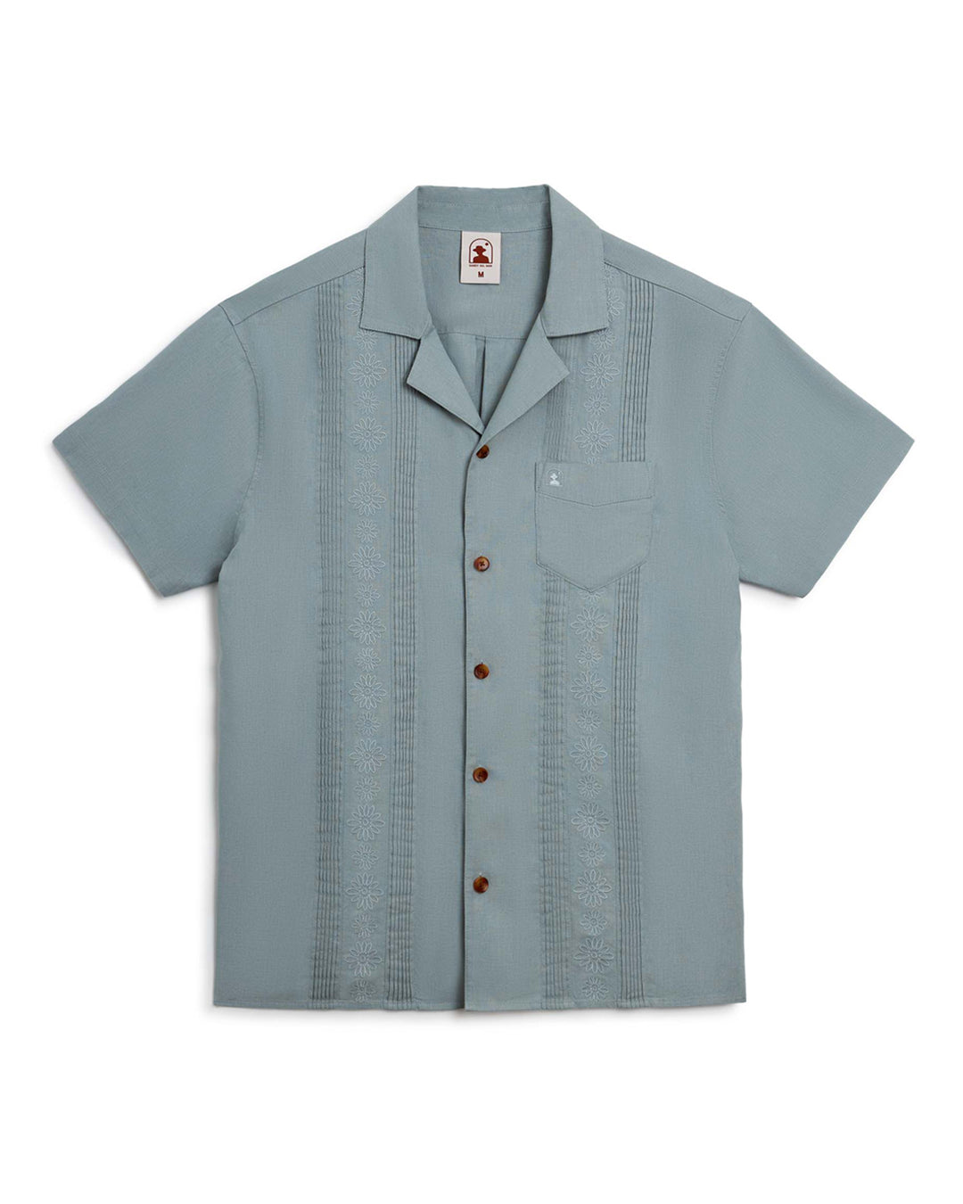 The Abalone Linen Shirt, a men's hawaiian shirt in light blue, with signature gardenia floral embroidery and coconut shell buttons, from Dandy Del Mar.