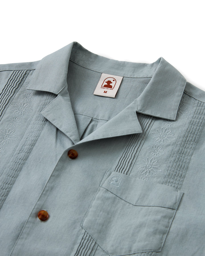 A light blue Dandy Del Mar Brisa Linen shirt with a button down collar and coconut shell buttons.