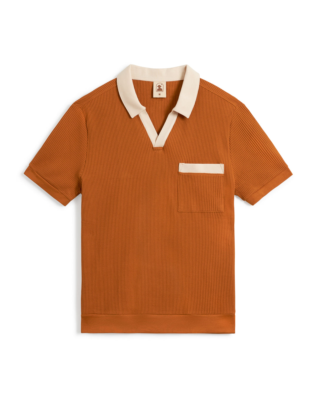 A short-sleeve **The Cannes Waffle Knit Shirt - Burnt Sienna** by **Dandy Del Mar** in burnt orange with a contrasting beige V-neck polo collar and chest pocket trim, crafted from waffle knit fabric.
