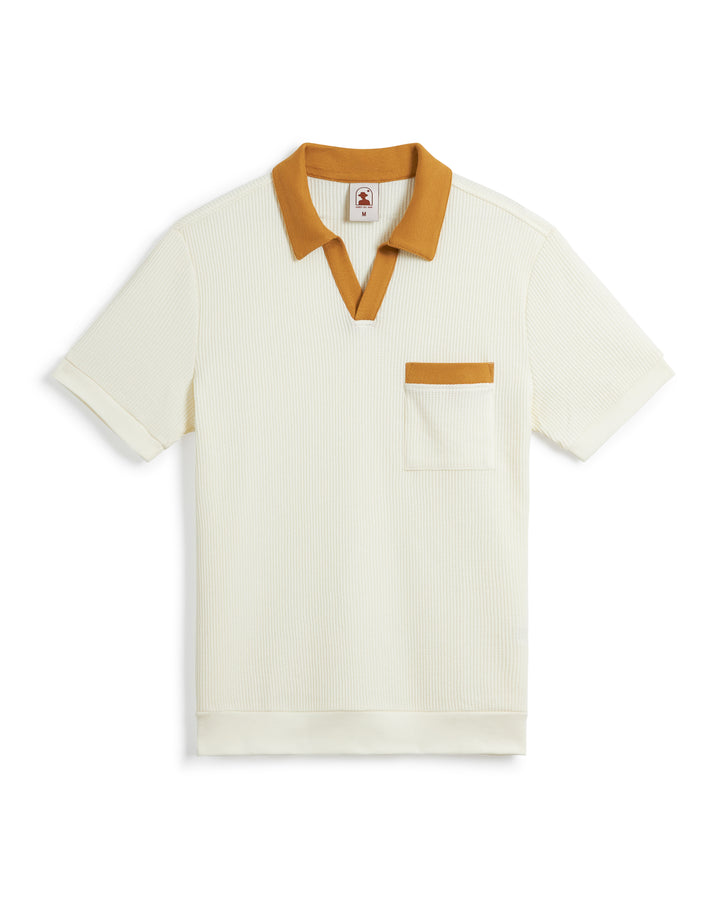 A white short-sleeve polo shirt with a ribbed texture, mustard yellow collar, and pocket trim. This Dandy Del Mar Cannes Waffle Knit Shirt - Vintage Ivory features a buttonless polo collar and subtle waffle knit fabric for added style and comfort.