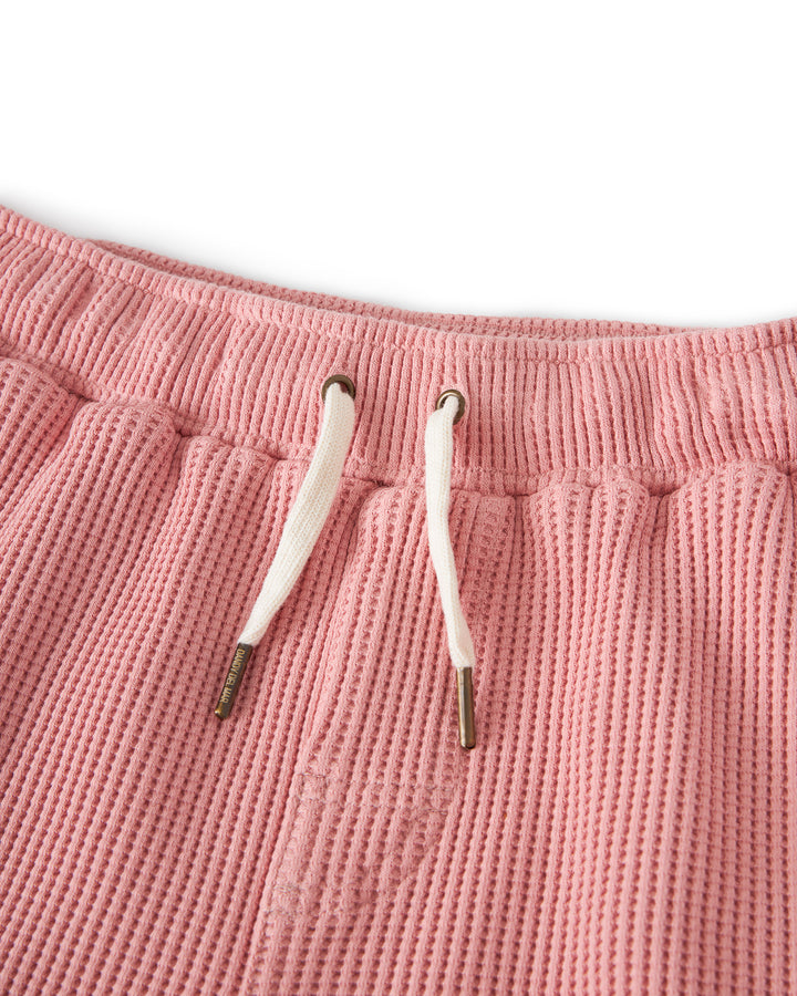 Close-up of the waistband of Dandy Del Mar The Cannes Waffle Knit Shorts - Spanish Rose with white drawstrings and metal tips, showcasing their 100% cotton construction.