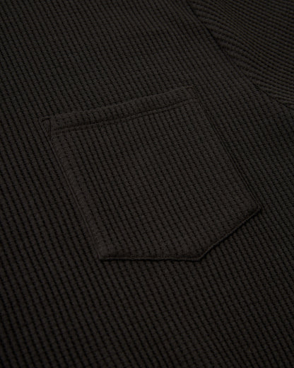 Close-up of The Cannes Waffle Knit Tee - Albatross by Dandy Del Mar, highlighting the dark waffle knit texture and a single pocket with sewing details.