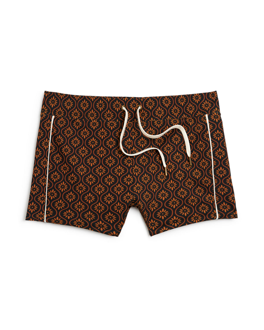 A Dandy Del Mar Cassis Square Cut Swim Brief - Cacao featuring a geometric pattern in brown and black.