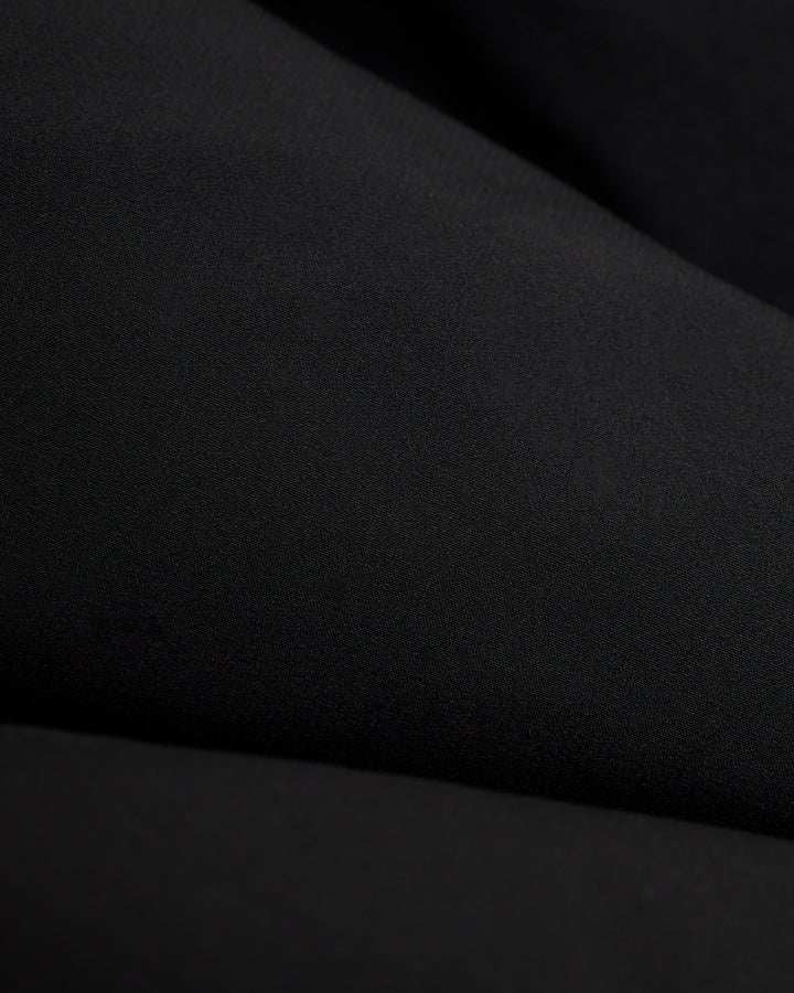 A close up image of The Cavoli Swim Short - Onyx by Dandy Del Mar, a black fabric.