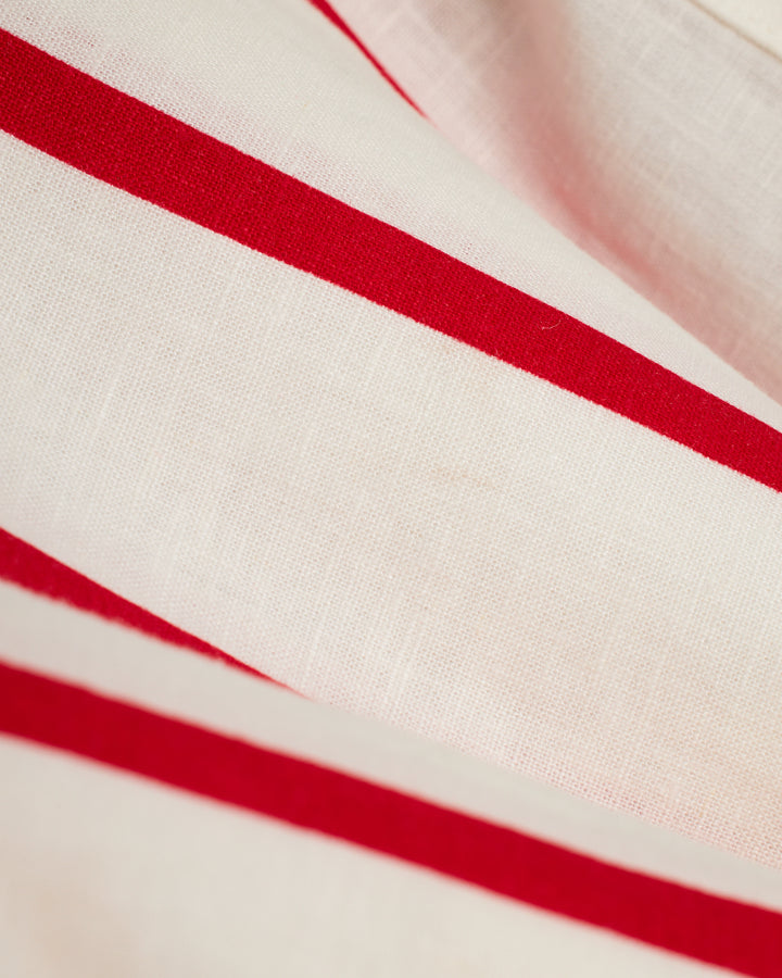 A close up of The Crete Linen Shirt - Pico by Dandy Del Mar, a red and white striped fabric.