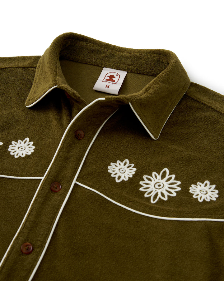 A green Gaucho Shirt with white flowers on it, from the brand Dandy Del Mar.