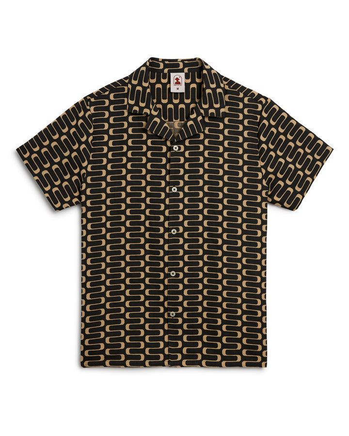 Product description: The lightweight Grenadine Shirt - Truffle features a stunning geometric pattern in black and gold by Dandy Del Mar.