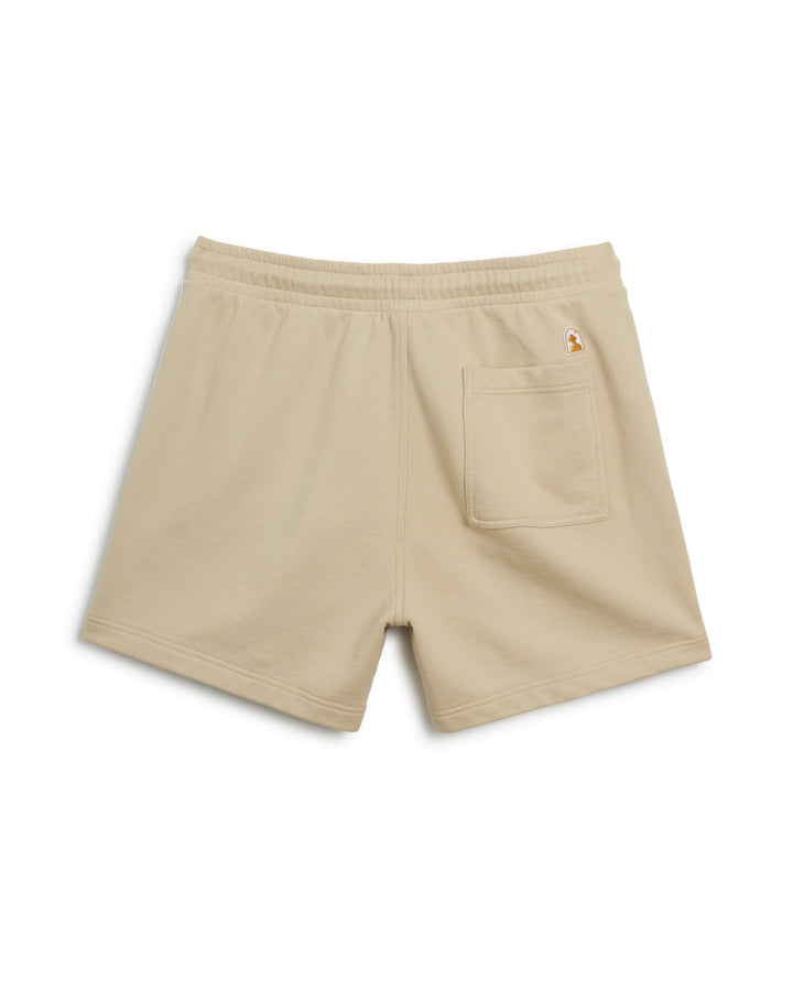 The Ginger Marseille Short is a women's beige short crafted from soft French terry fabric, featuring a statement orange pocket. Perfect for sports or casual wear.