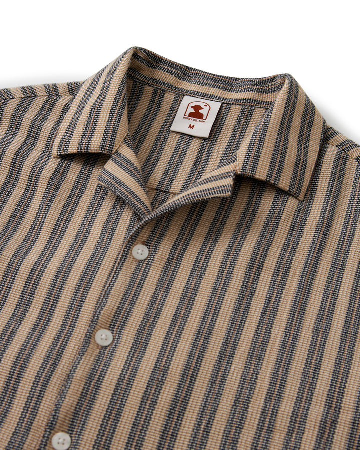 The Palma Shirt - Cacao Stripe by Dandy Del Mar is an equatorial essential, featuring tan and black stripes. The perfect getaway shirt for any occasion.