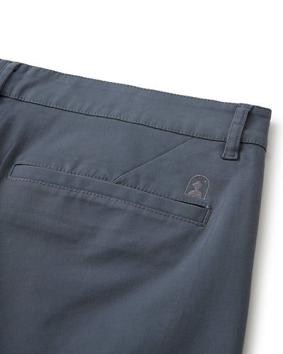 Close-up of the back pocket and waistband of The Rhodes Twill Shorts - Abyss by Dandy Del Mar, made from washed cotton twill, with a stitched logo above the pocket and a belt loop at the waistband.
