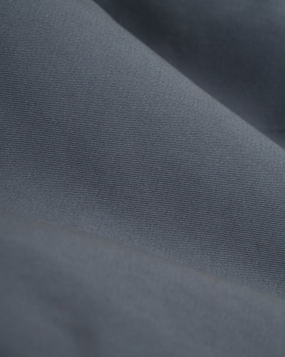 Close-up of dark gray washed cotton twill with visible texture and folds, featured in Dandy Del Mar’s The Rhodes Twill Shorts - Abyss men’s walk shorts.