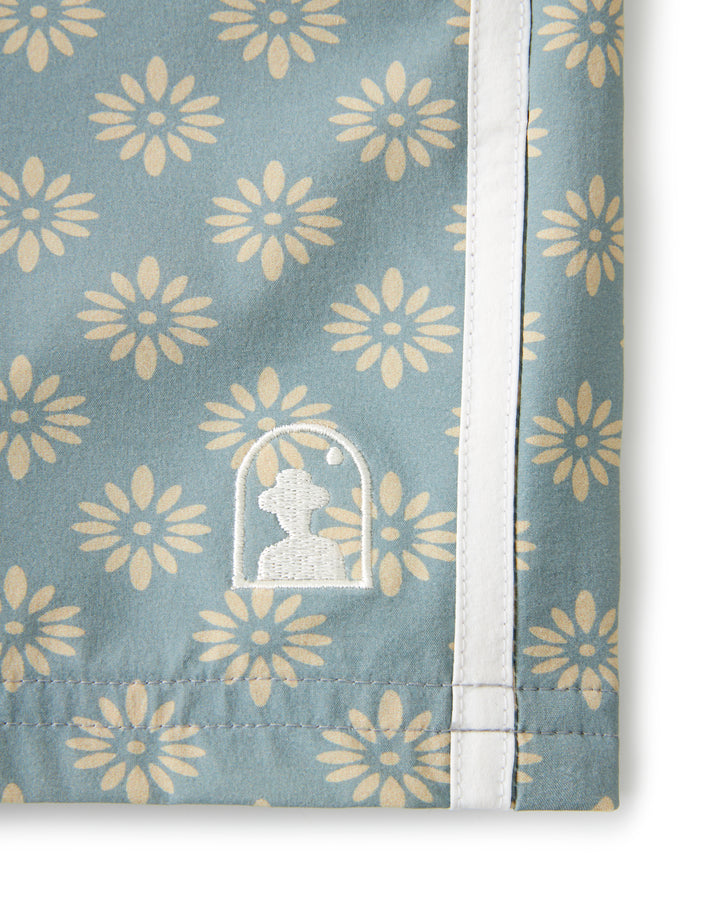 A Dandy Del Mar water resistant blue towel with a flower pattern on it, called The Stirata Short - Abalone.