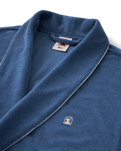 The Tropez Robe - Annapolis by Dandy Del Mar is an ultra-soft blue bathrobe with white piping, crafted from Terry Cloth. It includes a small embroidered logo, a size tag for M/L in the collar, and offers an above-the-knee fit for style and comfort.