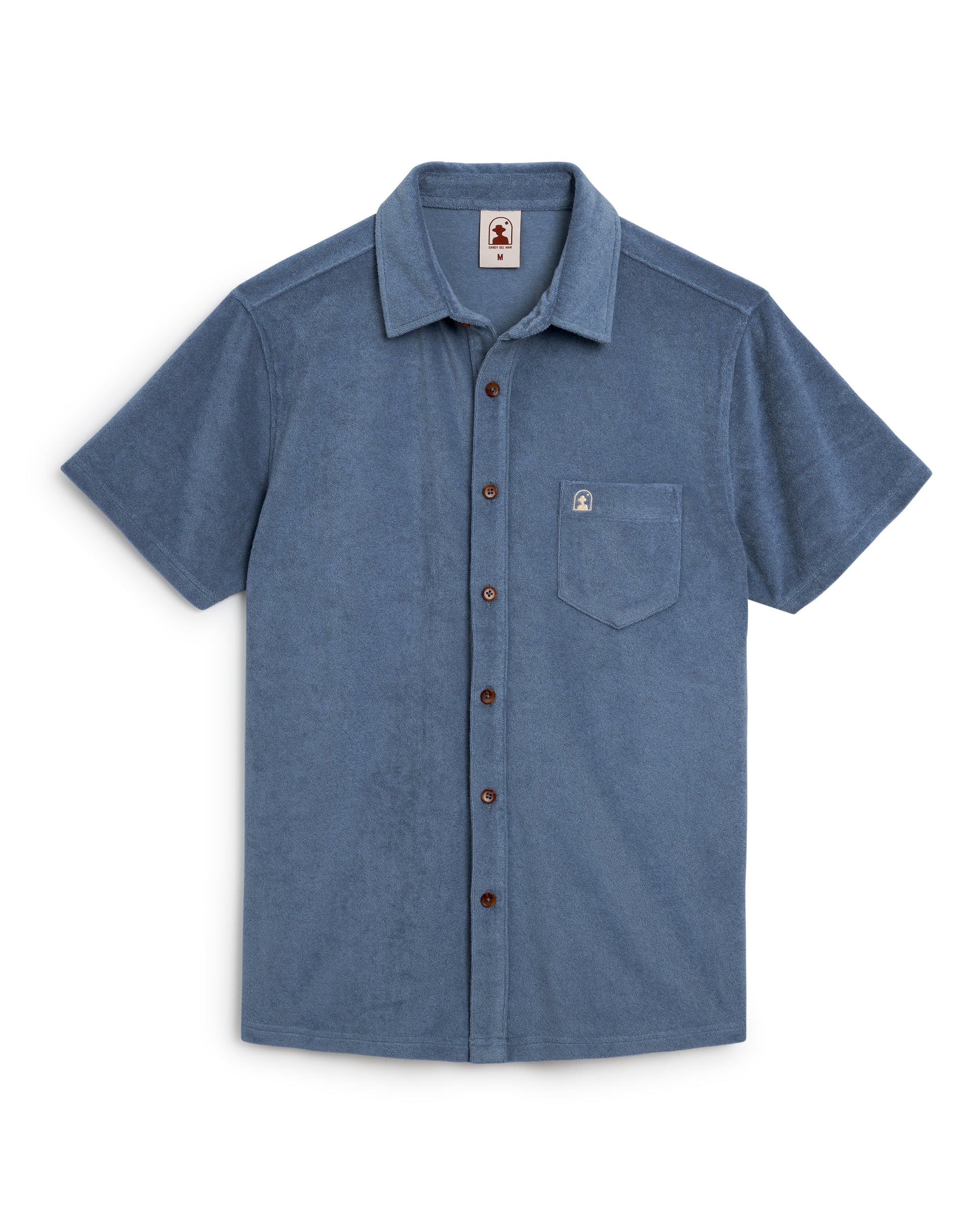 The Tropez Shirt - Annapolis by Dandy Del Mar is a short-sleeve blue button-up in premium terry cloth, featuring brown buttons and a small logo on the left pocket—a nod to stylish Côte d'Azur days.