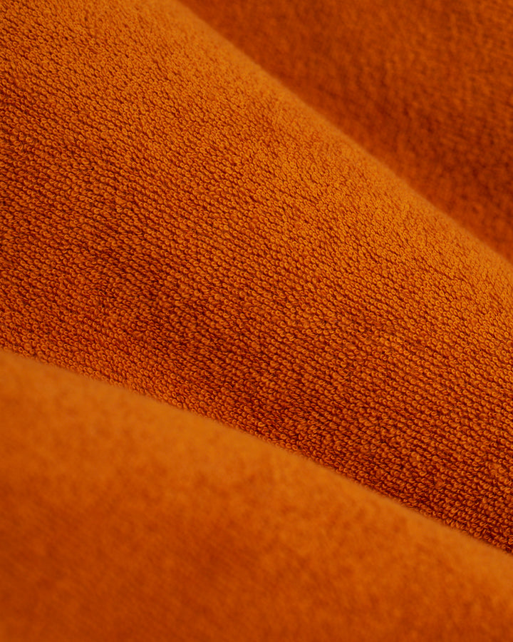 A close-up image of orange fabric, perfect for the Dandy Del Mar Tropez Short - Burnt Sienna or California lounge shorts.