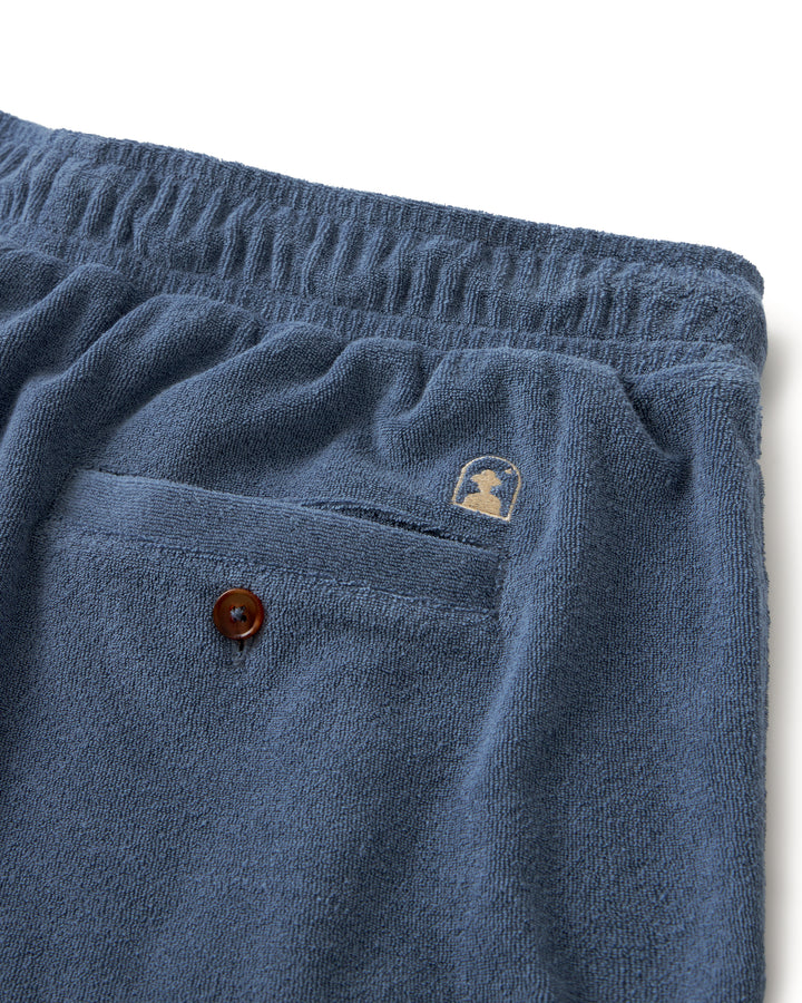 A pair of Dandy Del Mar Tropez shorts in a vibrant blue color with a button on the pocket.
