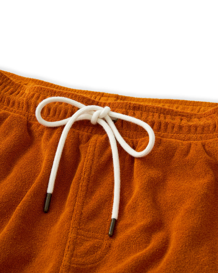 A pair of The Tropez Short - Burnt Sienna swim shorts with a white drawstring perfect for lounging by the pool in Côte d'Azur or St. Tropez by Dandy Del Mar.