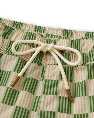 Close-up of Dandy Del Mar’s Ventura Volley Shorts - Arbequina in green and beige stripes, featuring an elastic waistband and white drawstring with metal tips—ideal men’s swim shorts for comfort and style.